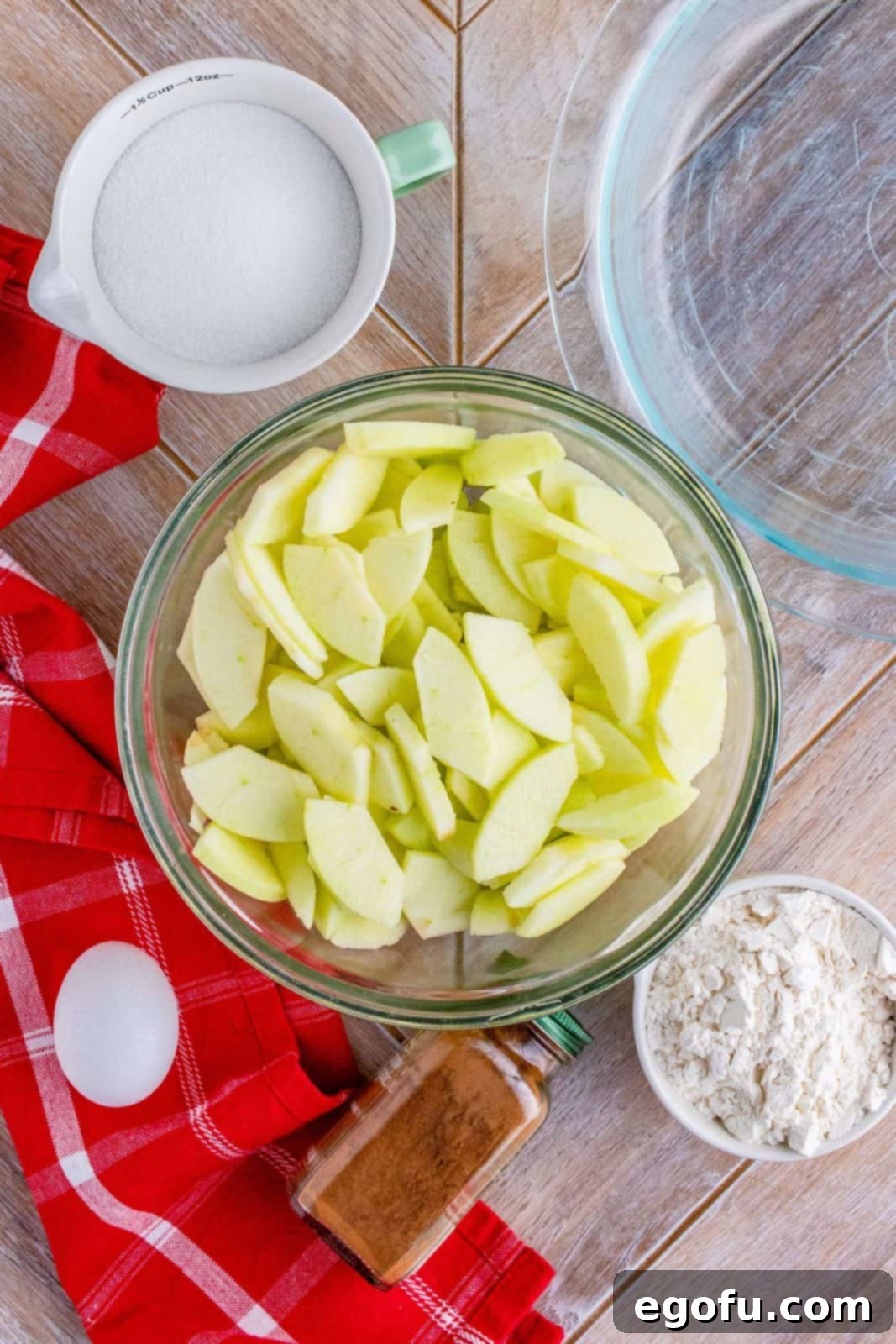 Grammies Homestyle Swedish Apple Pie 5 Sliced apples added to clear bowl.