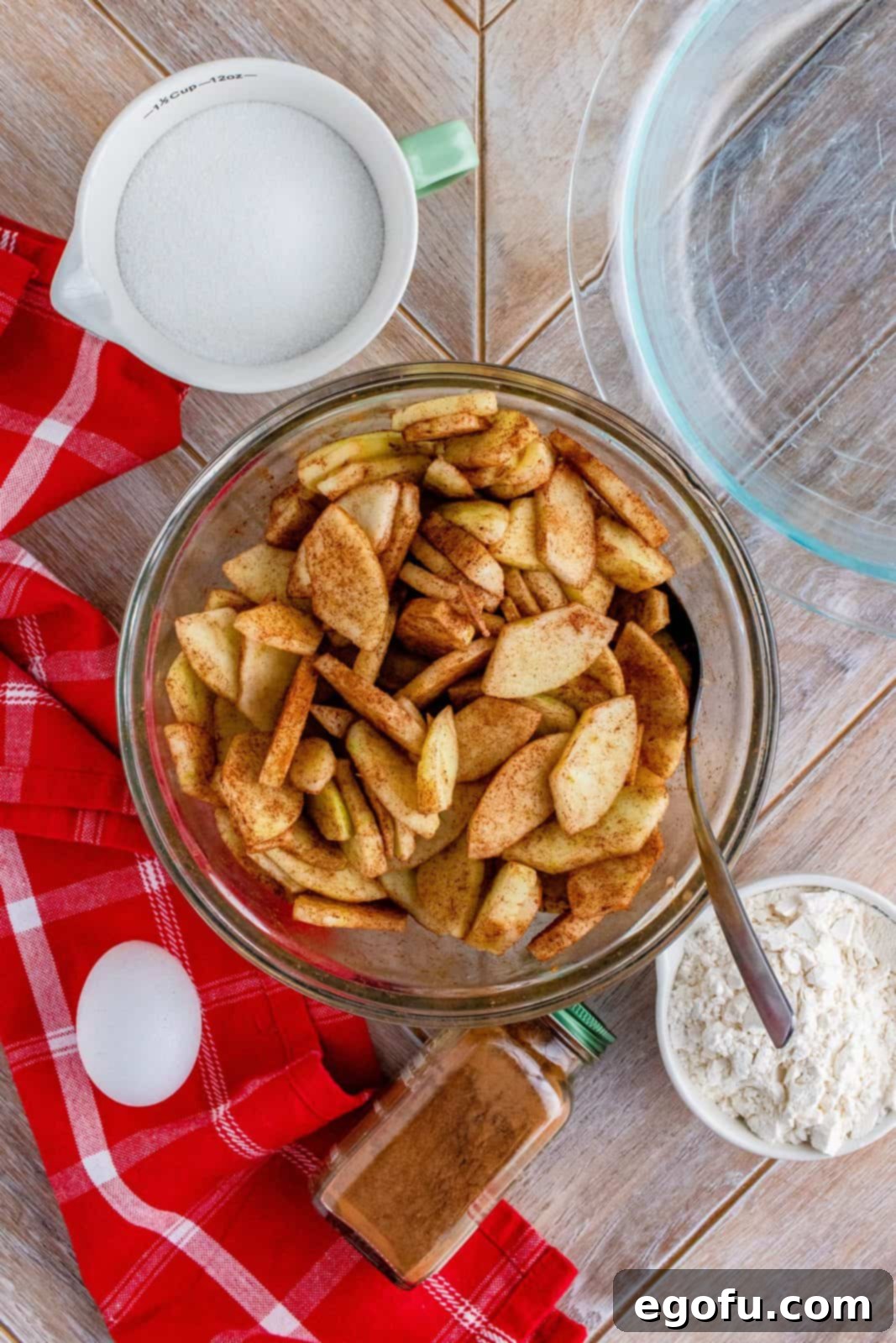 Grammies Homestyle Swedish Apple Pie 6 Sliced apples mixed with cinnamon and sugar in bowl.