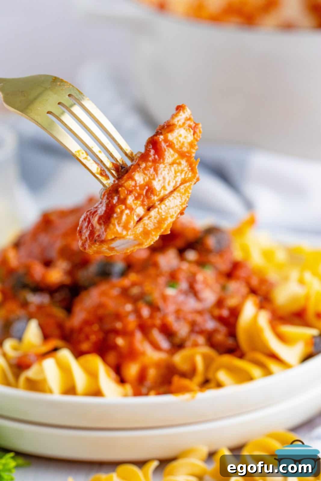 Fork holding up a bite of chicken from the Cacciatore dish.