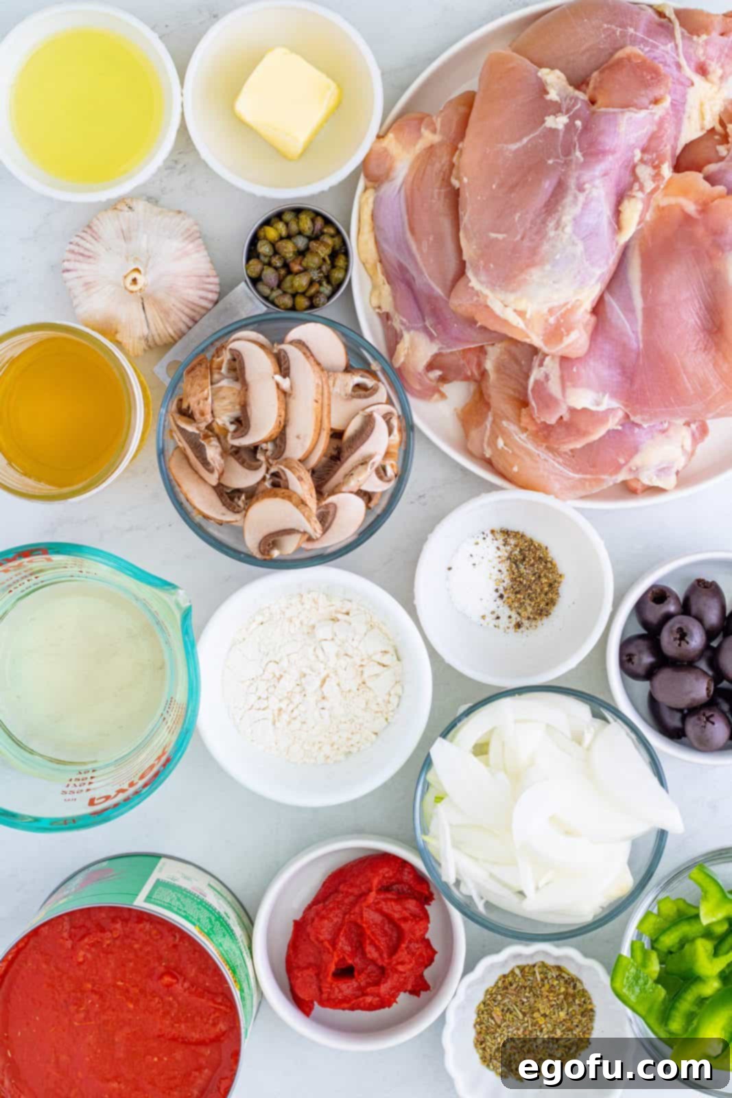 Ingredients for Chicken Cacciatore: chicken thighs, kosher salt, pepper, all-purpose flour, vegetable oil, unsalted butter, onion, green bell pepper, mushrooms, garlic, dry white wine, crushed tomatoes with basil, chicken stock, tomato paste, ½ cup black pitted olives, capers, Italian seasoning, fresh parsley, and parmesan cheese.