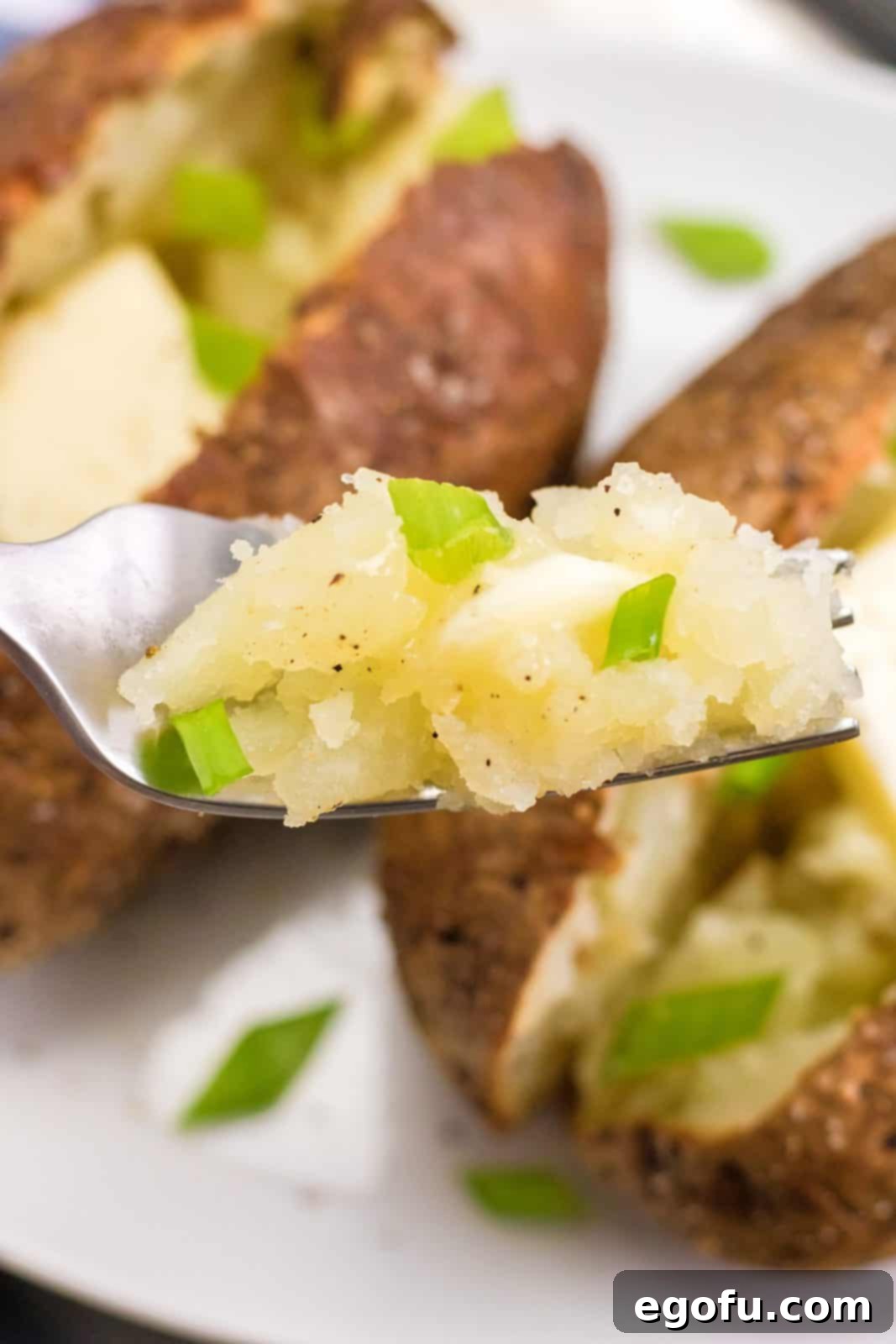 Fork holding up some of the Air Fryer Baked Potato.