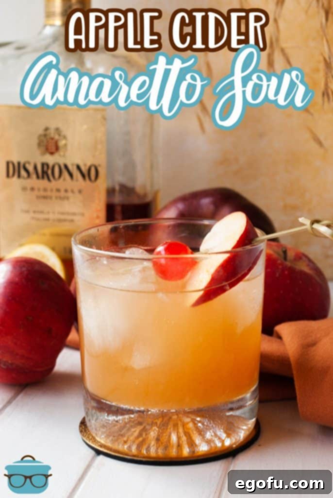 Pinterest image of finished Apple Cider Amaretto Sour garnished with cherry and apple slice, perfect for fall inspiration.