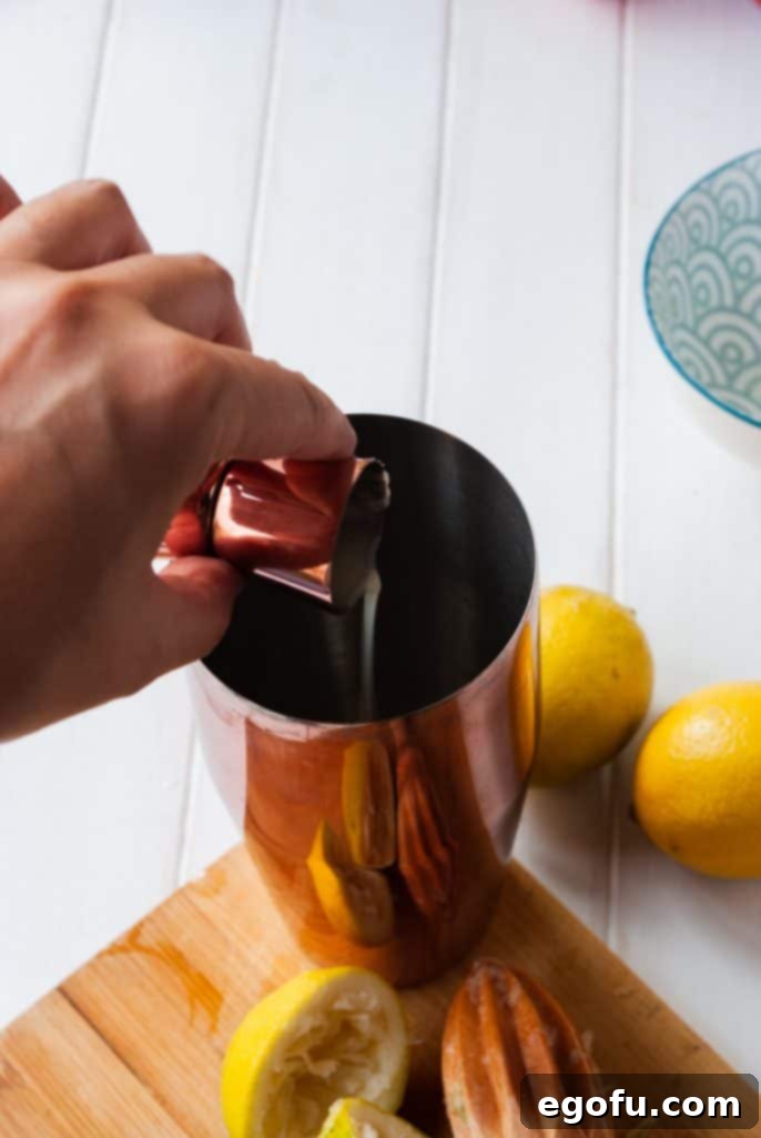 Amaretto liqueur being added to a cocktail shaker with other ingredients.