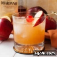 Square image of Apple Cider Amaretto Sour in glass with cherry and apple slice.
