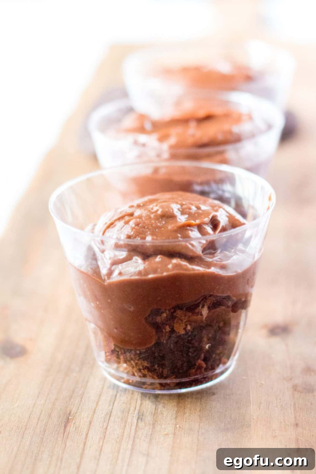 Pudding added to top of brownies in the cups, creating a smooth layer.