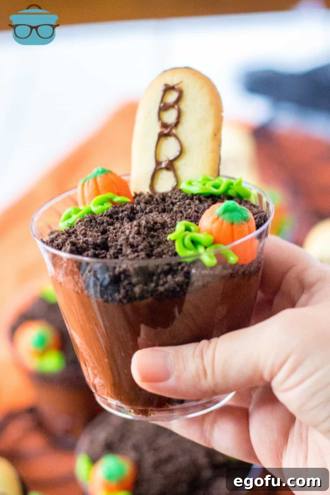 Hand holding up one finished Halloween Graveyard Cup, showcasing the complete spooky design.