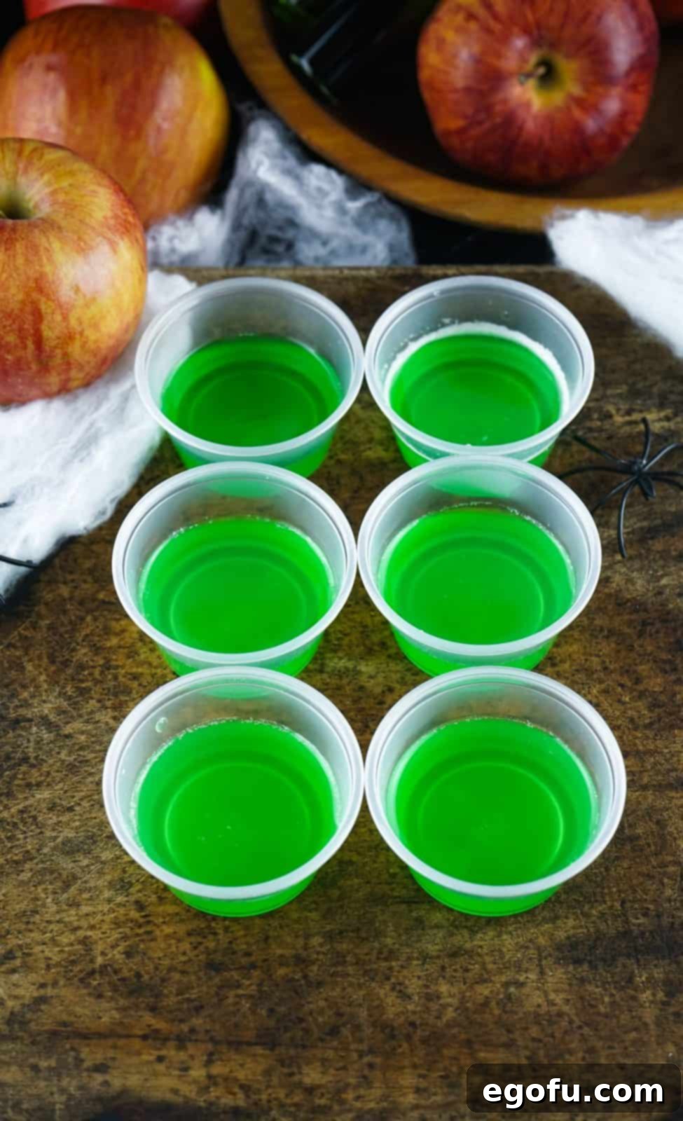Small plastic cups with jell-o mixture poured halfway in cups.