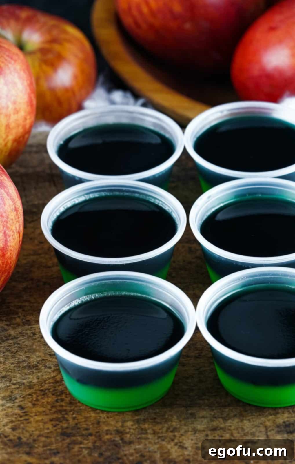 Black colored jell-o mixture added to the top of set green jell-o mixture.