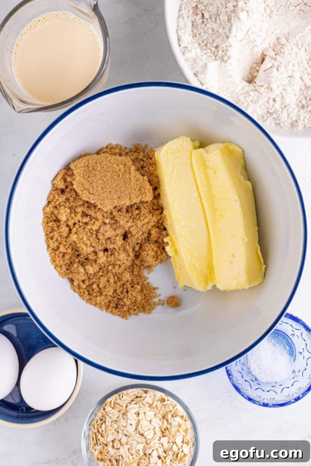 Brown sugar and softened butter being creamed together in a white bowl, showing a smooth texture.