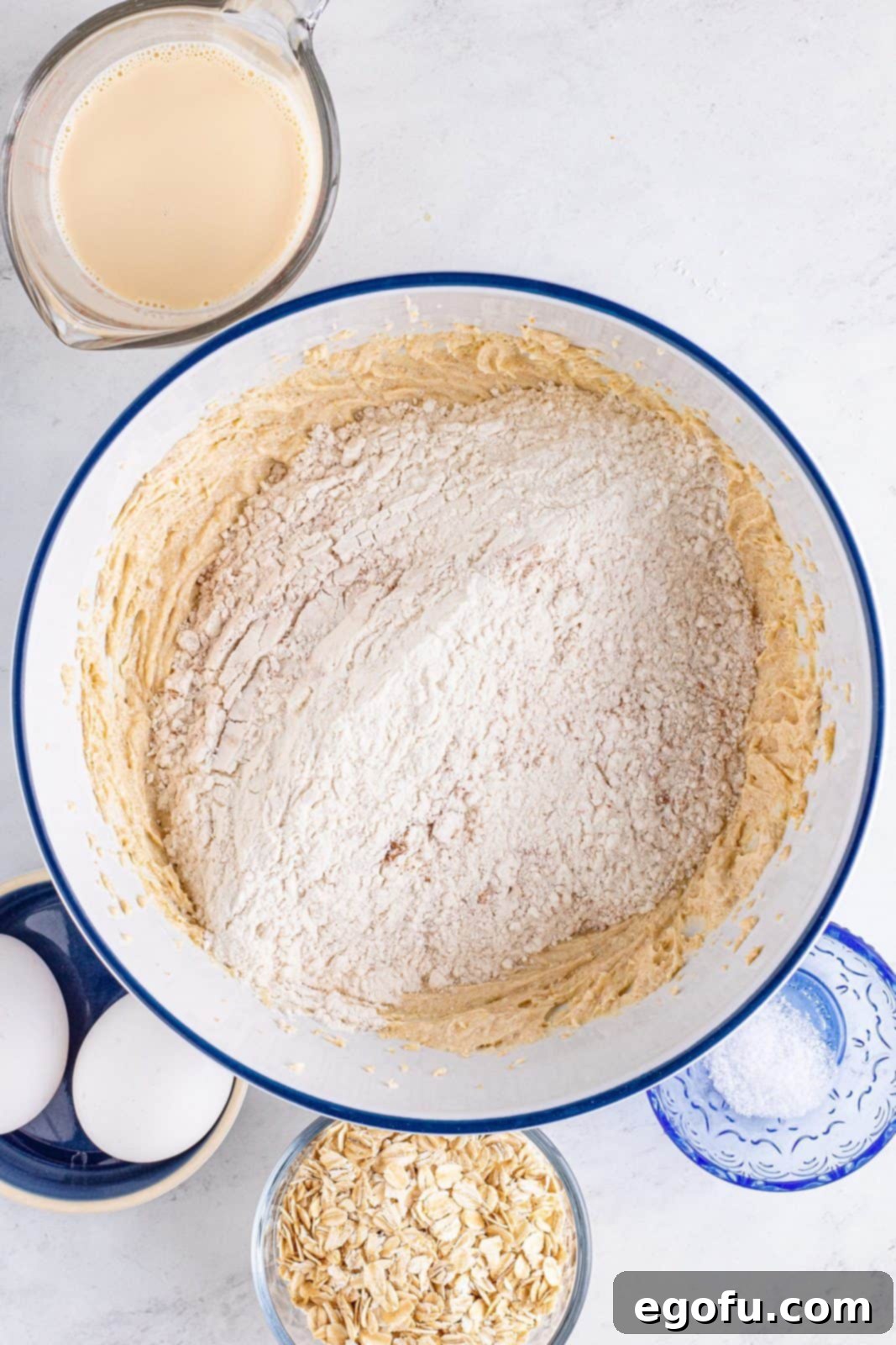 The mixed dry ingredients are added to the creamed butter and brown sugar in a bowl.