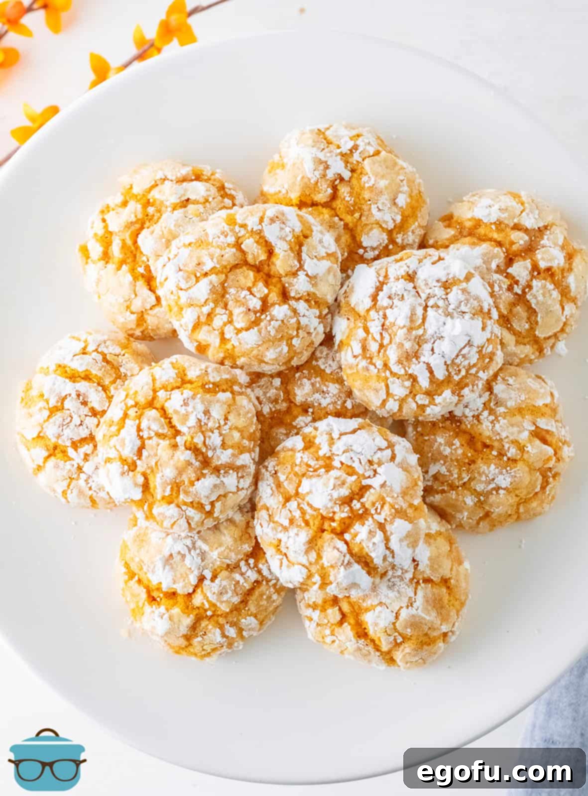 Fall Pumpkin Crinkle Delights 13 An inviting overhead photo of beautifully stacked Pumpkin Crinkle Cookies on a white plate, ready to be enjoyed.
