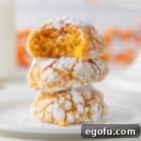 Fall Pumpkin Crinkle Delights 14 Square image of stacked cookies with a bite taken out of the top cookie, showcasing the tender interior.