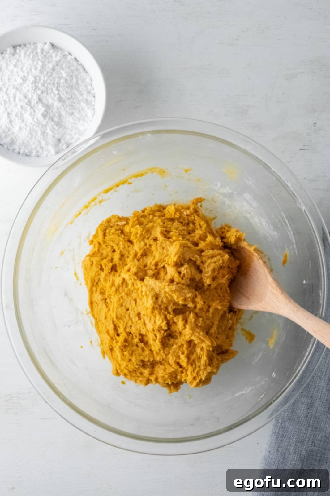 Fall Pumpkin Crinkle Delights 7 Dry ingredients carefully folded into the butter and sugar mixture, showing the initial stages of dough formation.