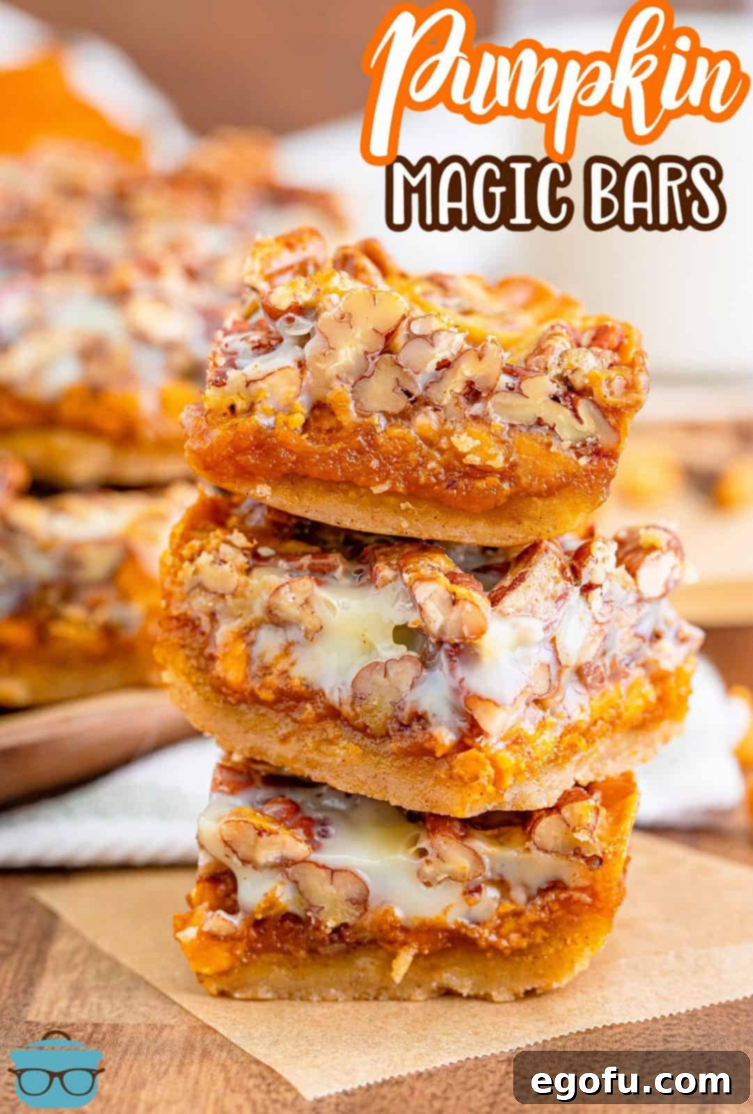 Autumn Magic Pumpkin Bars 3 Pinterest image of three stacked Pumpkin Magic Bars on parchment paper, ready for sharing.
