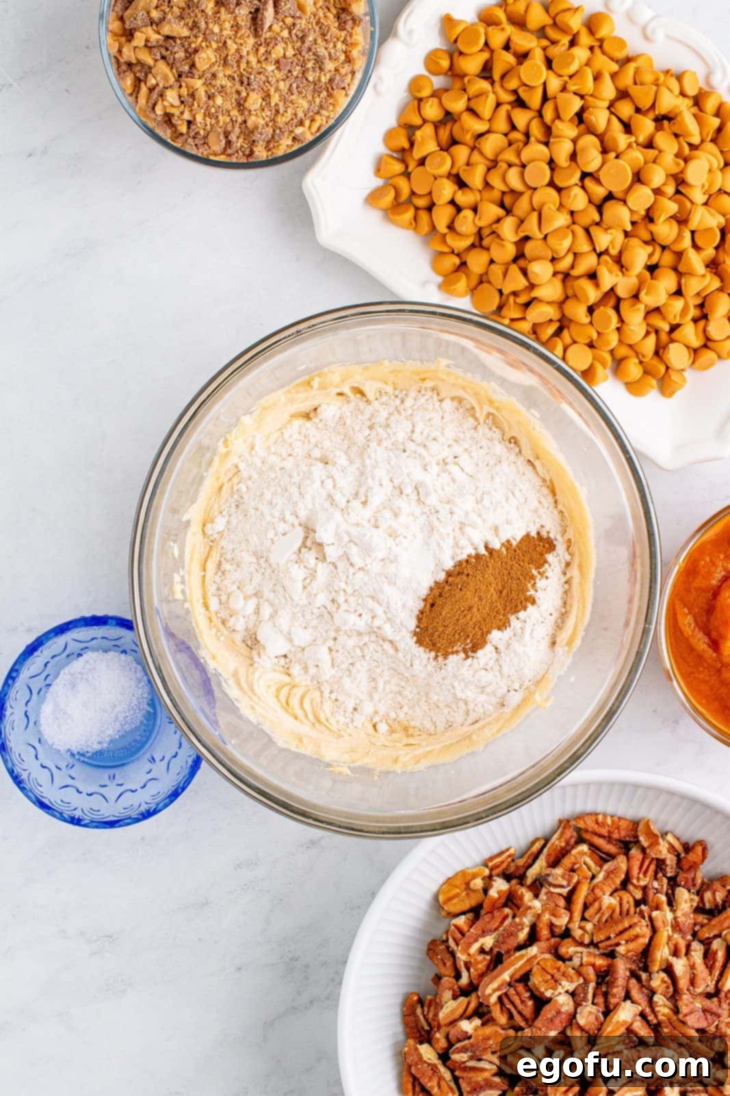 Autumn Magic Pumpkin Bars 6 Dry ingredients (flour, pumpkin pie spice, salt) added to the beaten butter and brown sugar in a bowl, ready to be mixed.