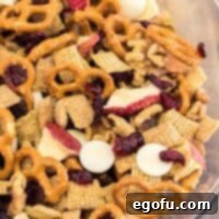 Square image close up of trail mix in clear bowl showing all ingredients.