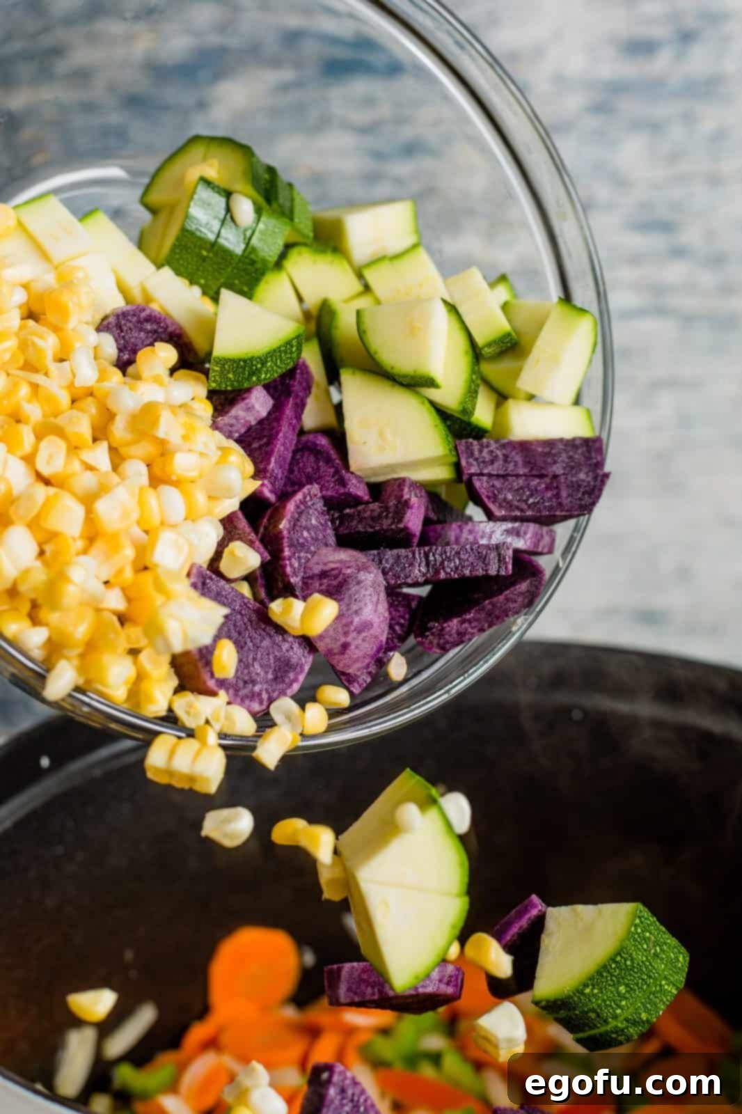 Golden Harvest Chicken and Rice Soup 6 Various ingredients including potatoes, zucchini, corn kernels, raw chicken pieces, uncooked rice, and seasonings added into a large pot, ready for the broth.