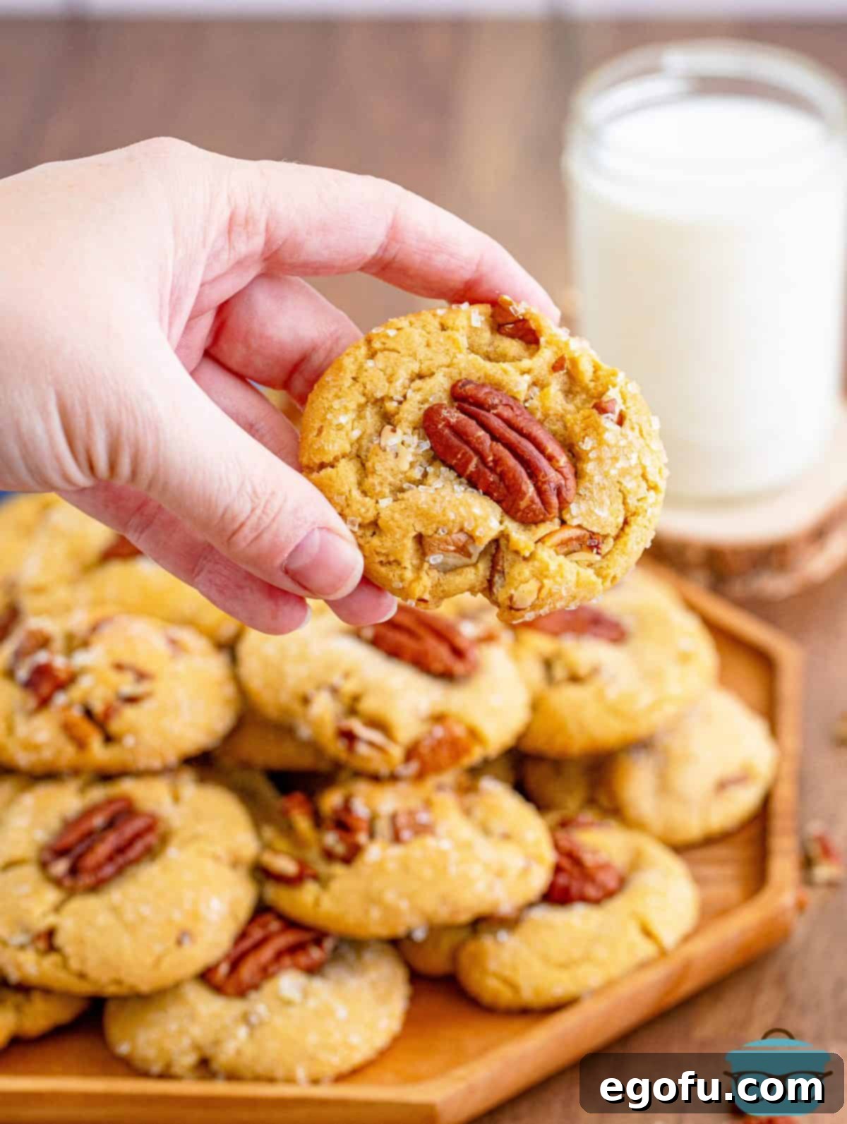 Hand holding up one Butter Pecan Cookie.