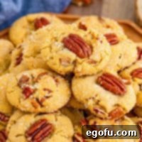 Square image close up of Butter Pecan Cookies on wooden platter.