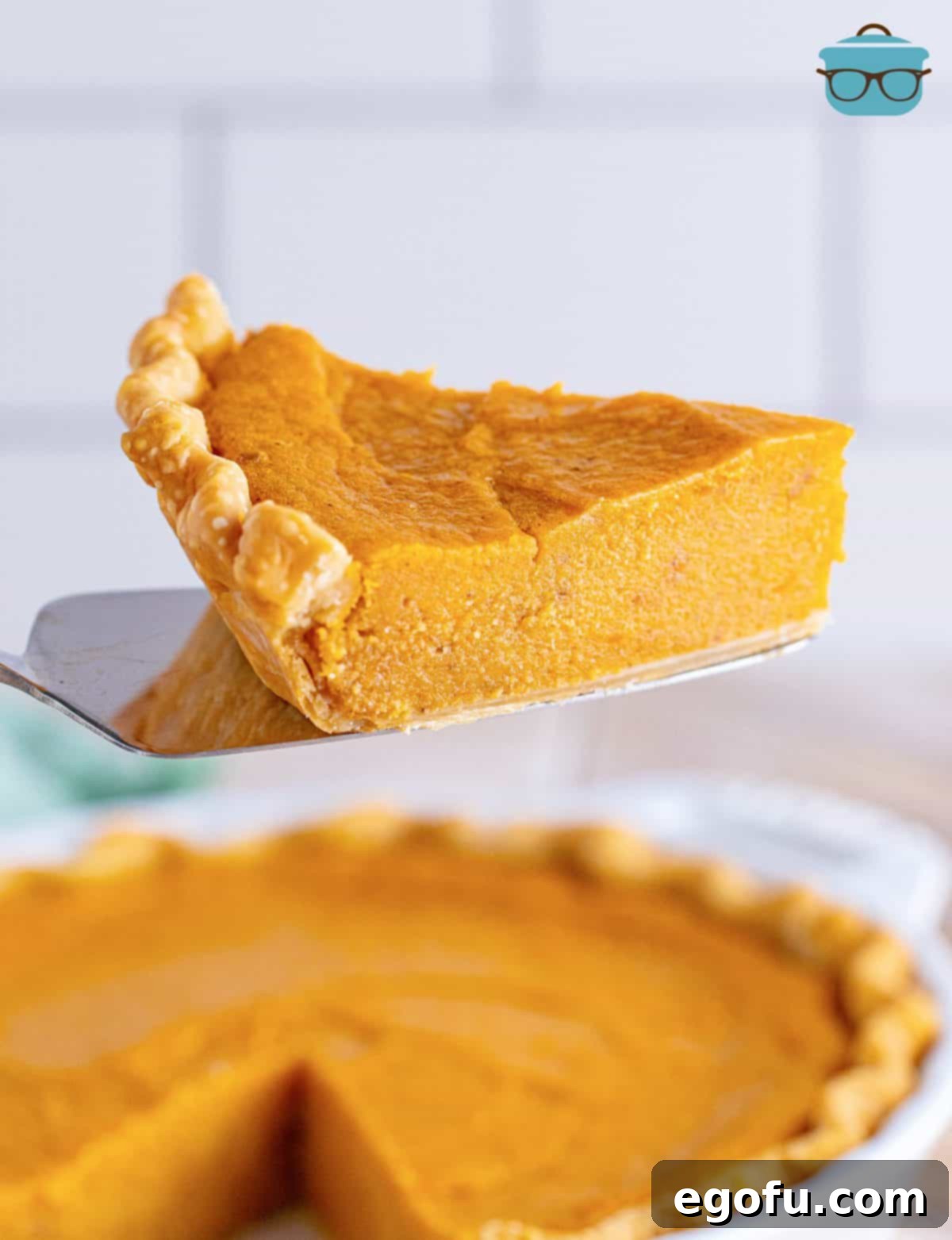 Velvet Sweet Potato Dream Pie 12 Pie server holding up a piece of Sweet Potato Pie.