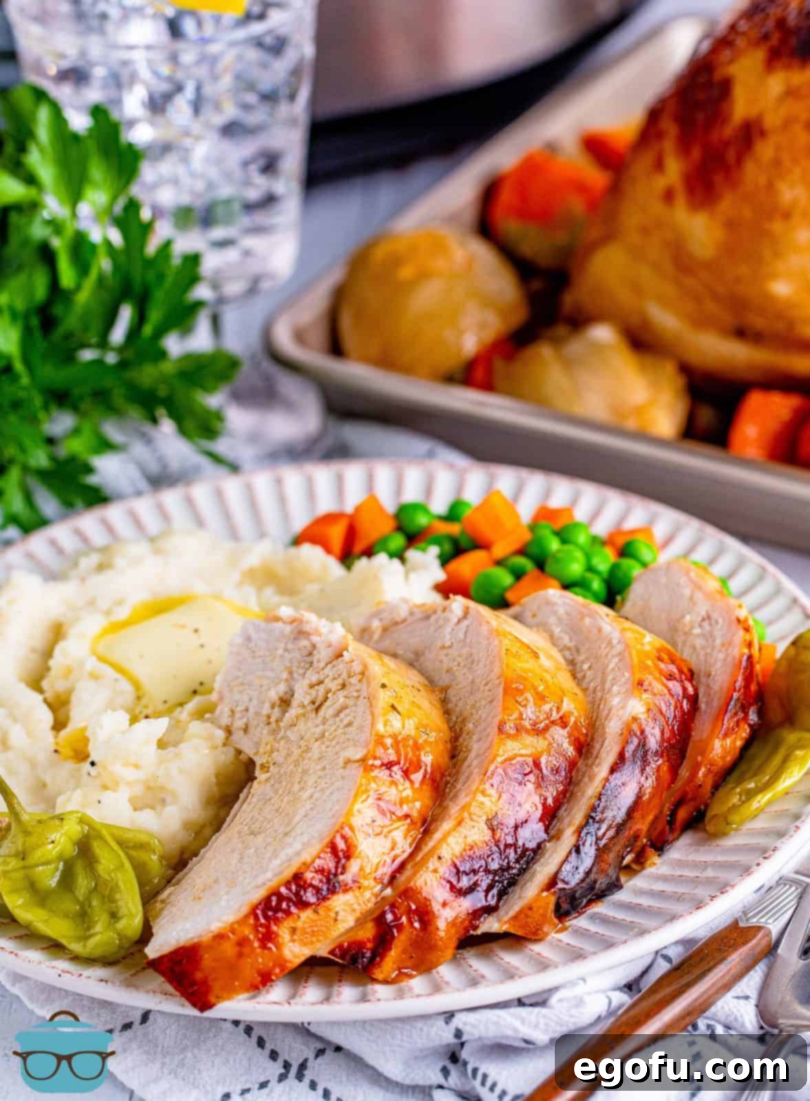 Sliced and plated Crock Pot Mississippi Turkey Breast with vegetables and mashed potatoes, ready to be enjoyed.