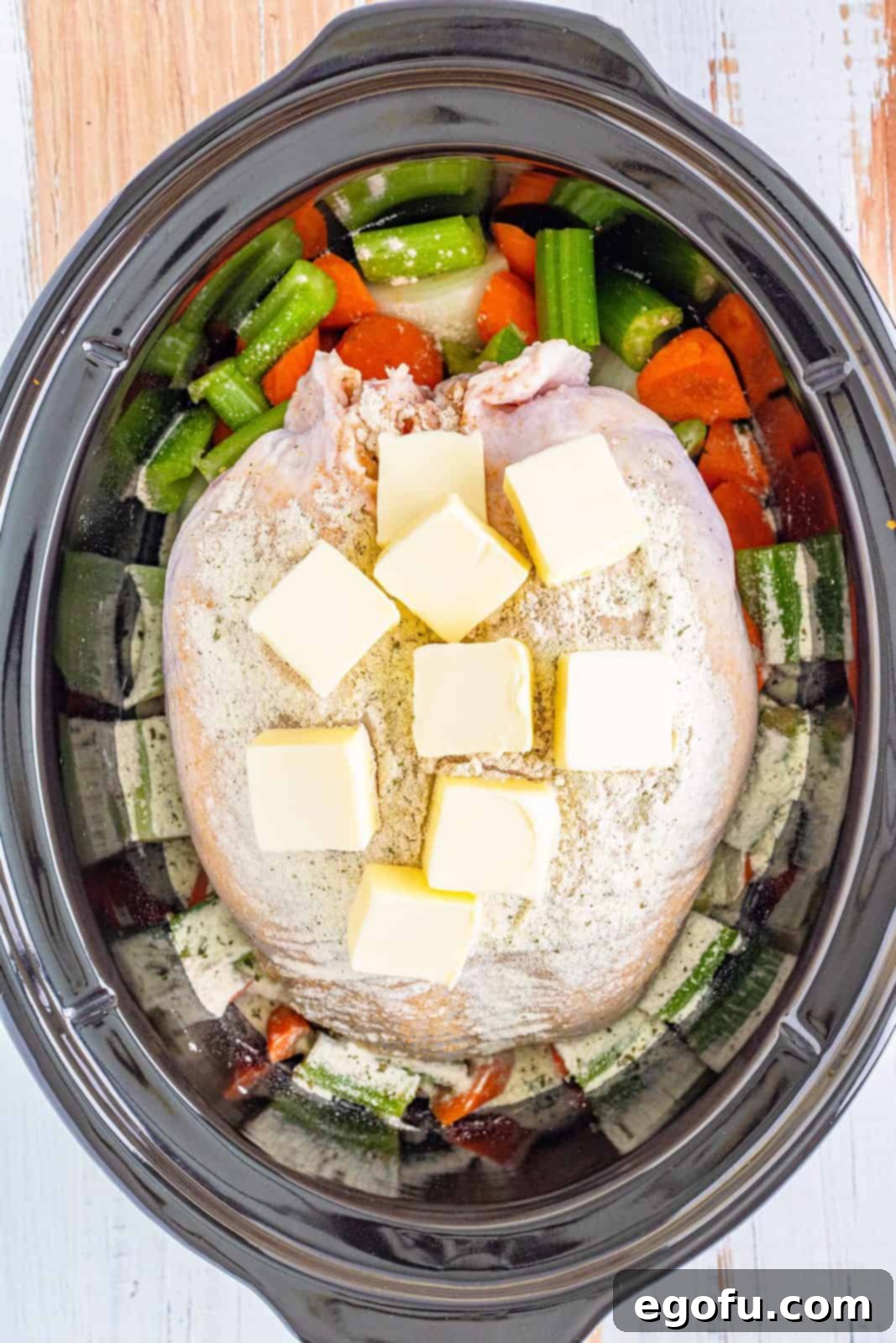 Pats of unsalted butter placed on top of the seasoned turkey breast.