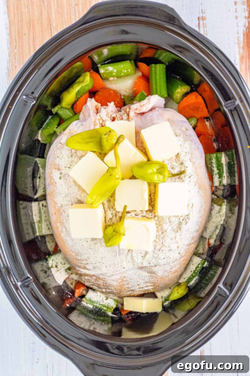 Pepperoncini peppers added to the top of the turkey breast in the slow cooker.