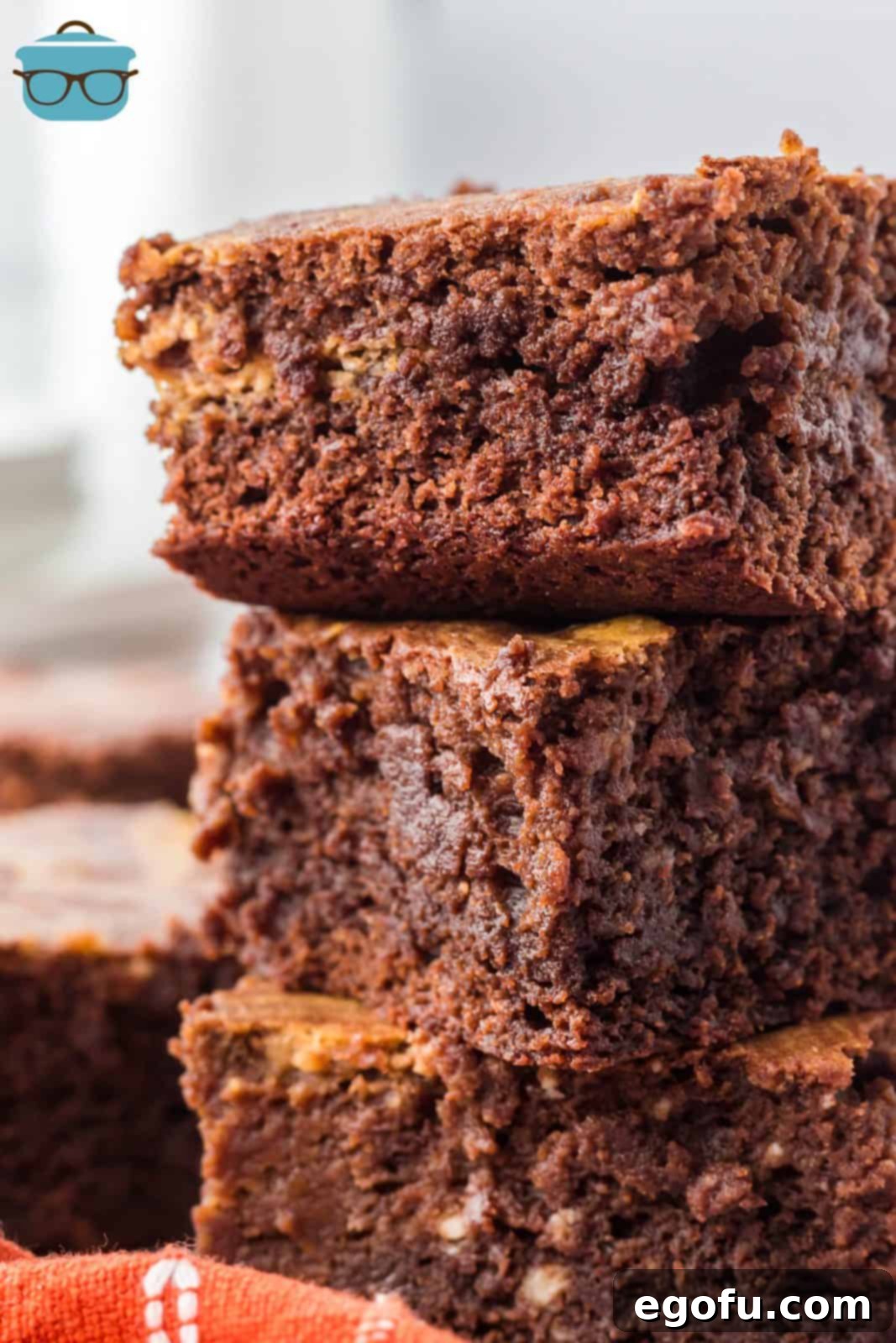 Three stacked Pumpkin Swirl Brownies close up showing the rich chocolate and pumpkin swirl texture.