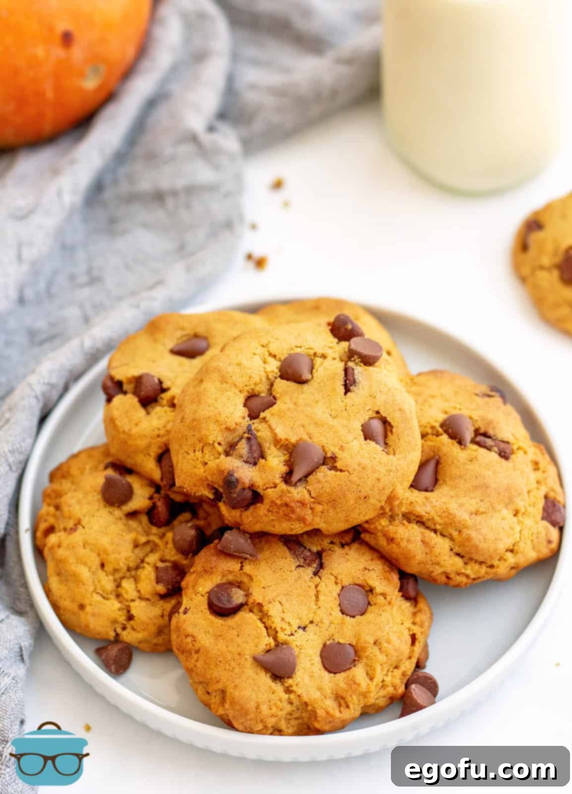 Pumpkin Chocolate Chip Cookies stacked on white plate.