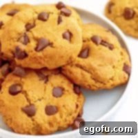 Close up square image of stacked Pumpkin Chocolate Chip Cookie Recipe on white plate.