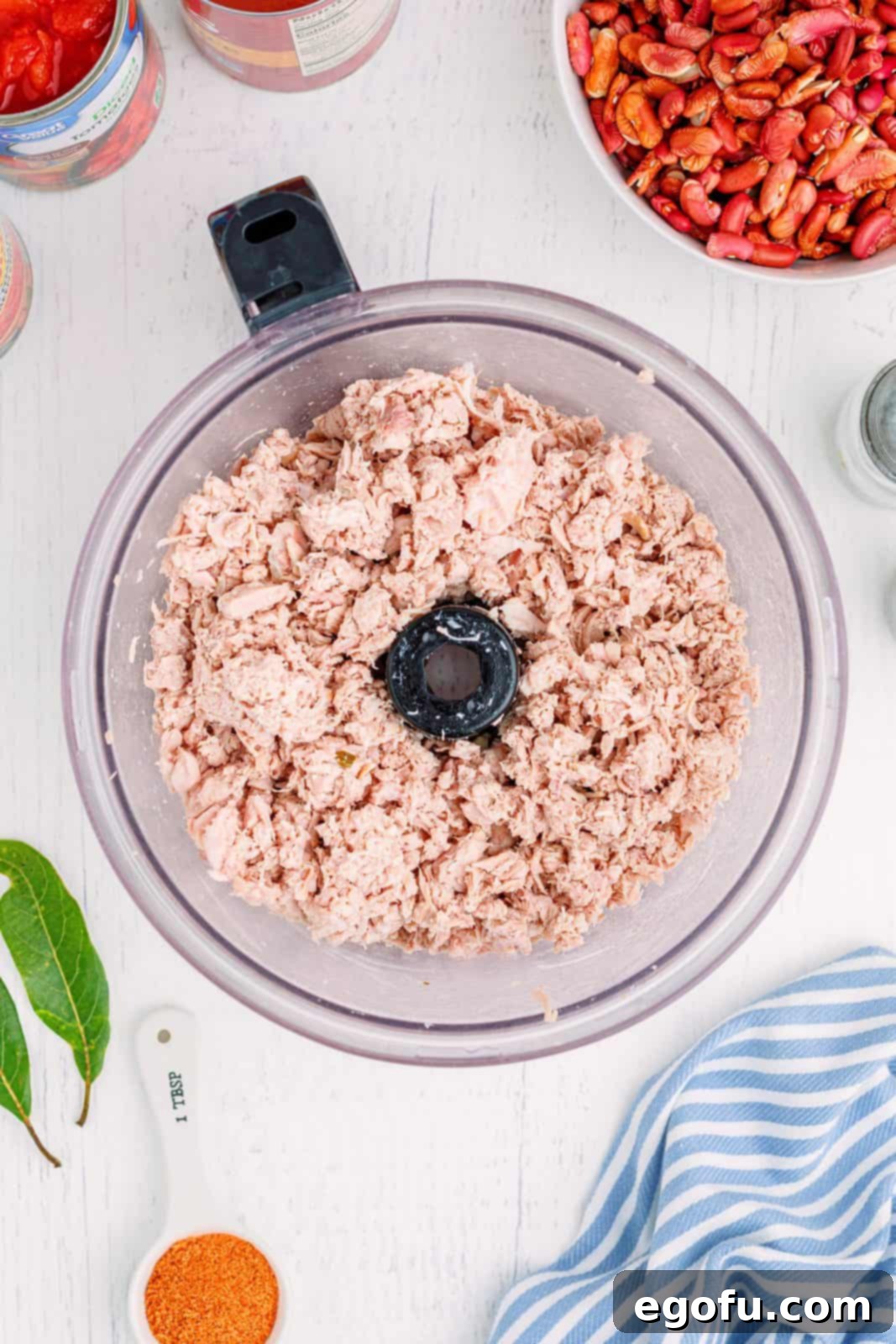 Cooked turkey added to a food processor and blended into smaller, ground-like chunks, ready for chili.