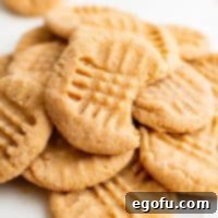 Square close up image of 3-Ingredient Peanut Butter Cookies, showcasing their golden texture, with a bite taken out of one for visual appeal.