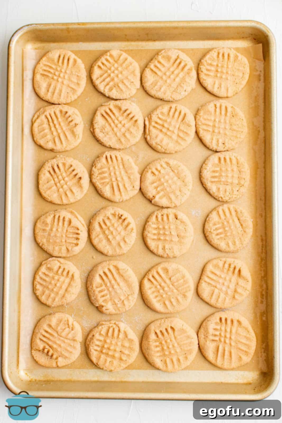A baking sheet filled with freshly baked 3-Ingredient Peanut Butter Cookies, golden at the edges and ready to cool.