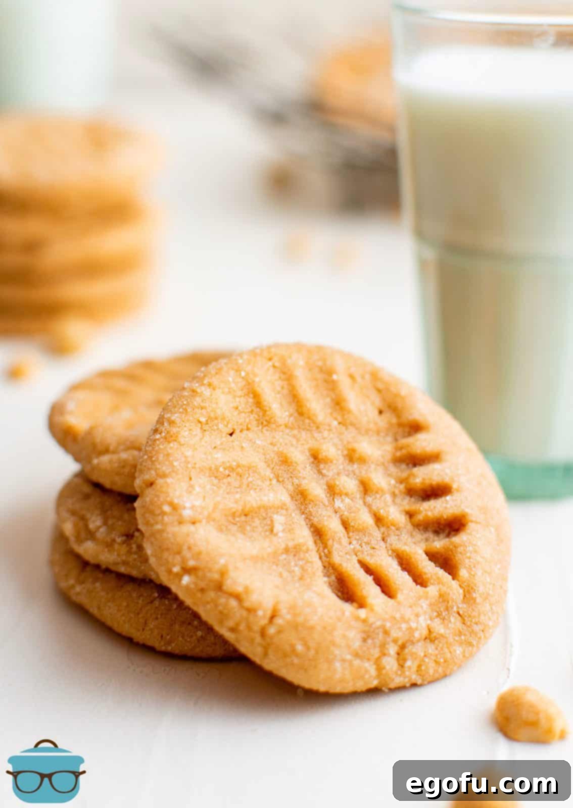 A beautiful stack of golden-brown 3-Ingredient Peanut Butter Cookies, perfectly baked and ready for serving, with one cookie leaning.