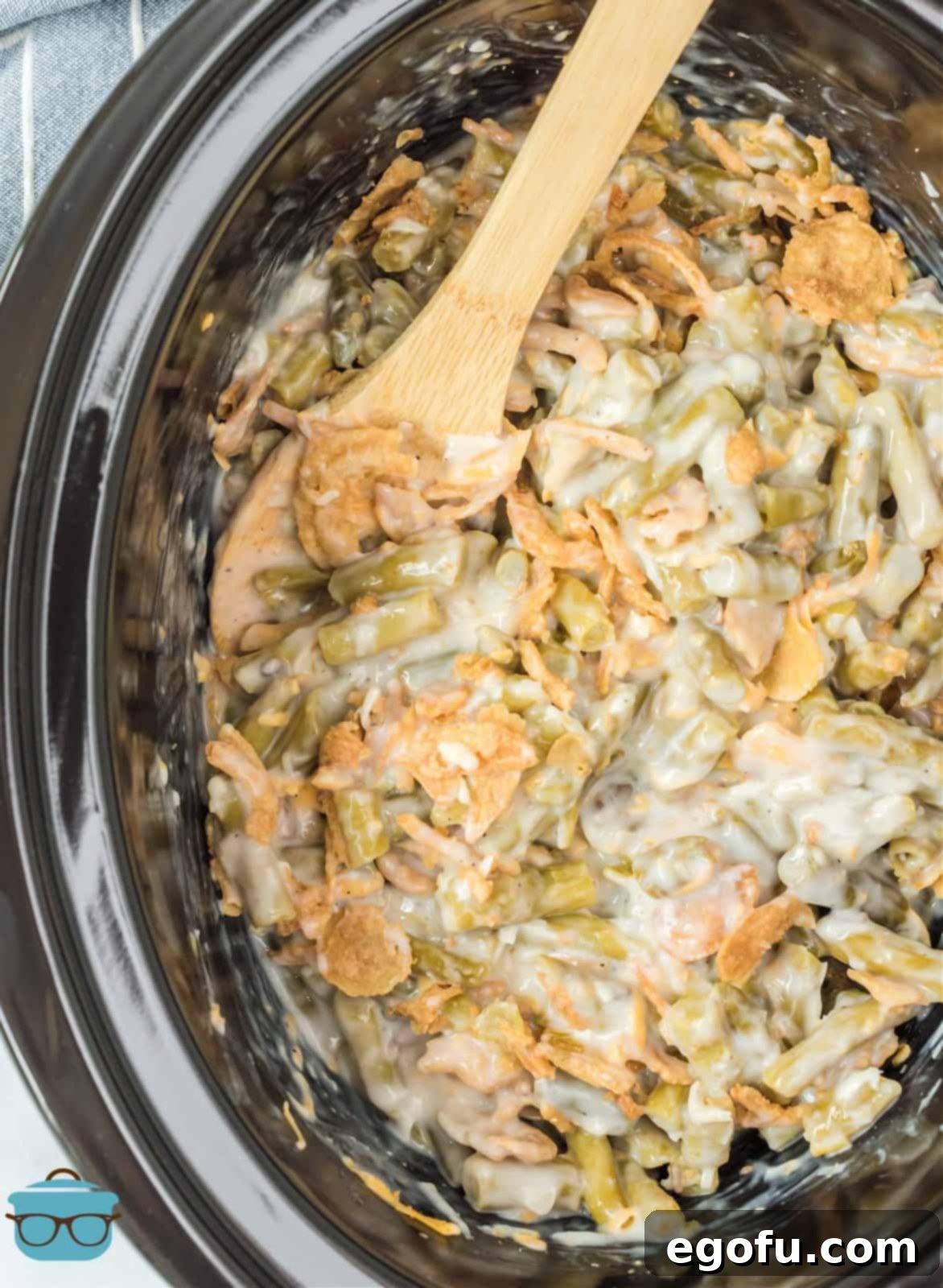 Crock Pot Green Bean Casserole overhead with spoon in crock pot.