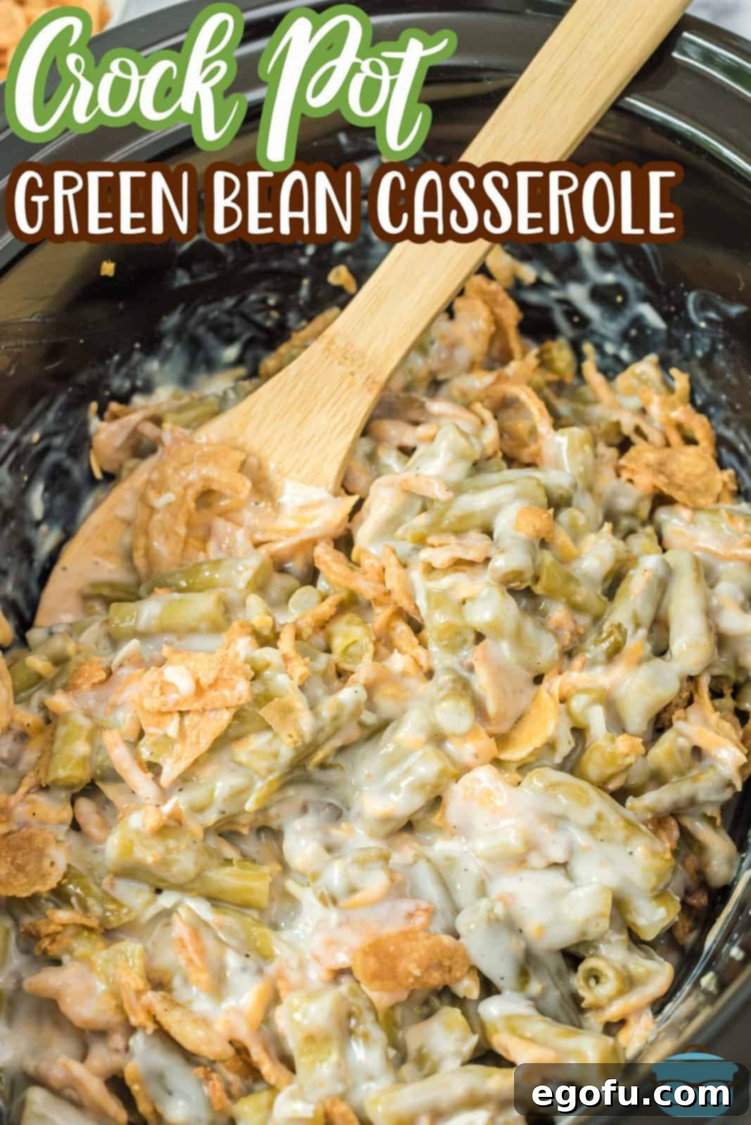 Pinterest image of finished Crock Pot Green Bean Casserole Recipe with spoon in casserole.