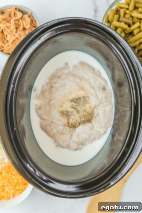 milk, cream of mushroom soup and seasonings added into slow cooker.