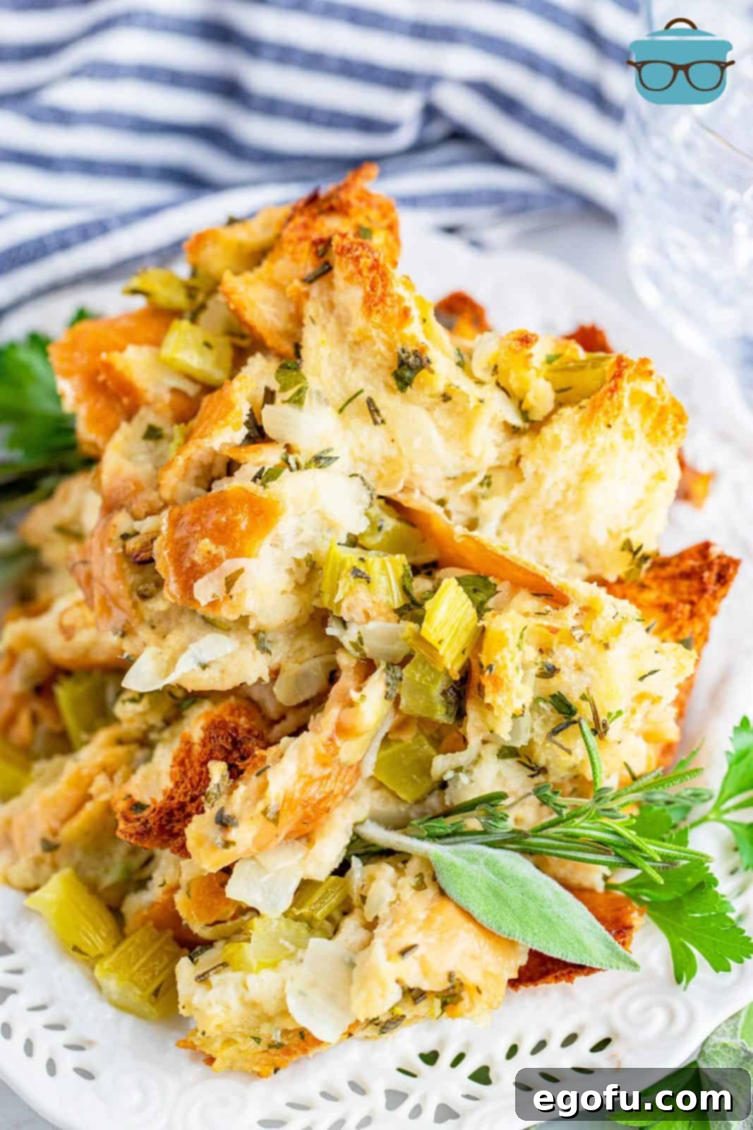 A serving of Easy Garlic and Herb Stuffing on a white plate, highlighting its golden-brown crust and fresh herbs.