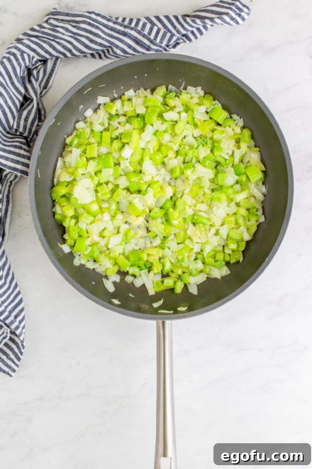 Diced onion, celery, and minced garlic sautéing in butter in a large skillet.
