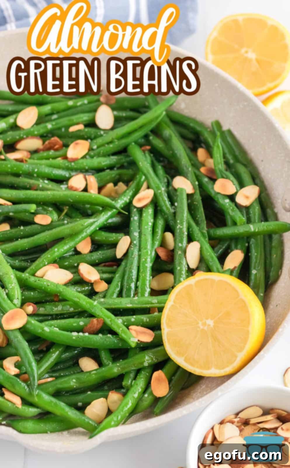 Pinterest image of finished Almond Green Beans with half a lemon.
