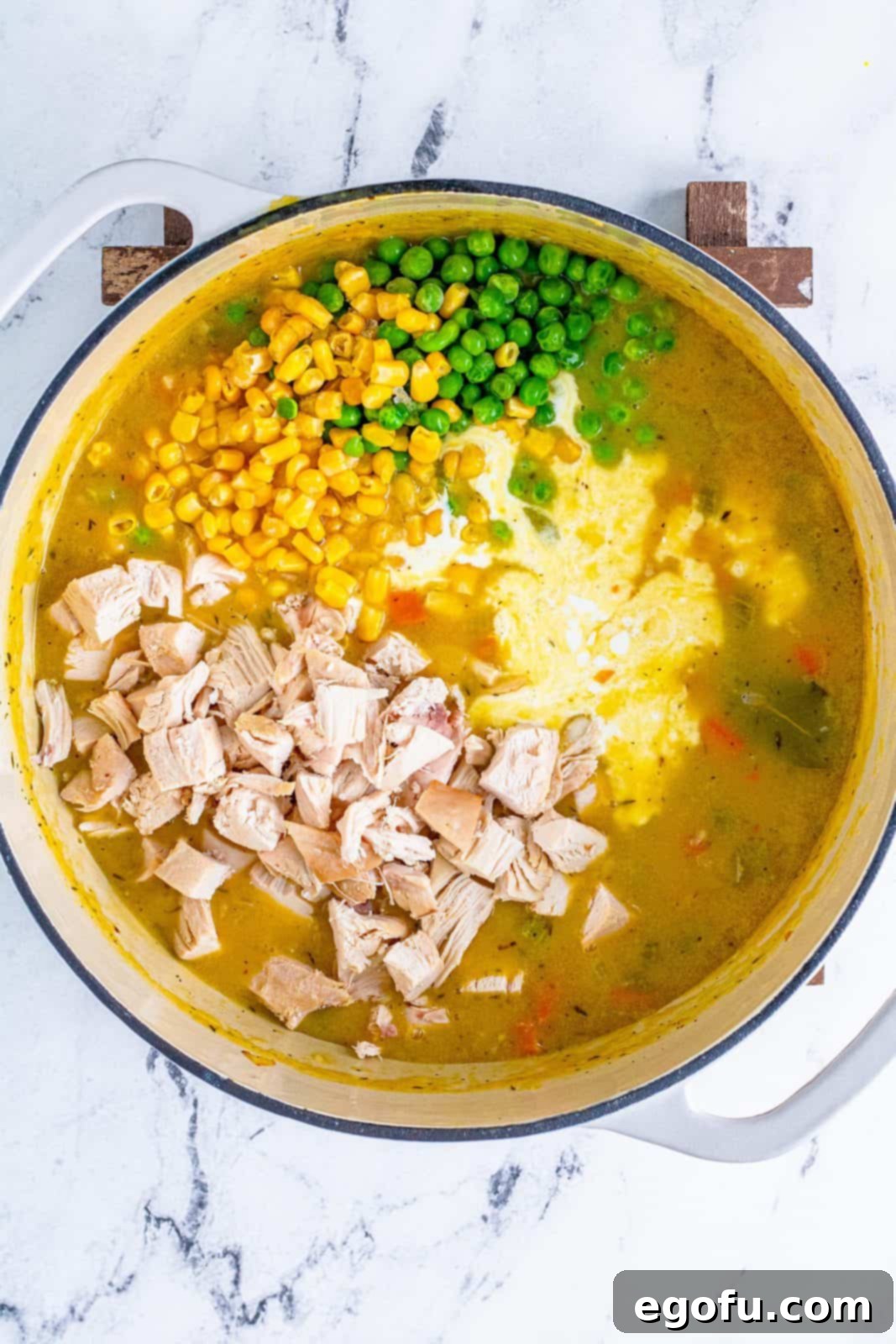Chicken, heavy cream, peas, and corn added to stockpot.