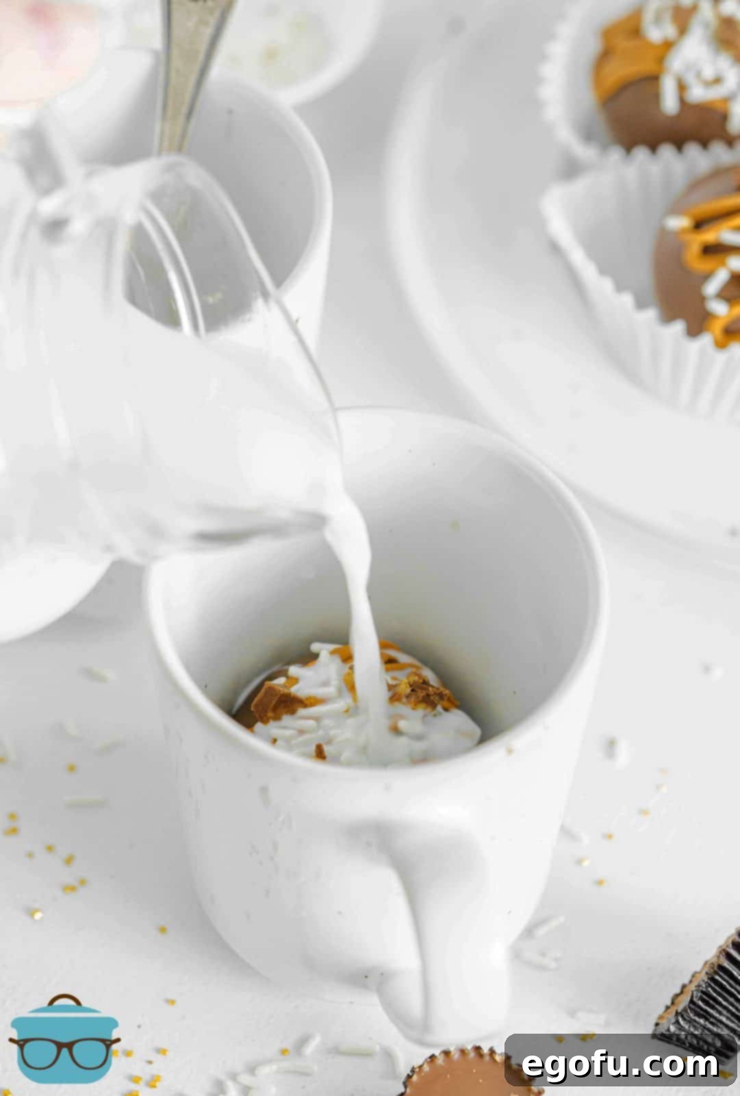 Milk being poured over Chocolate Peanut Butter Hot Cocoa Bomb in white mug.