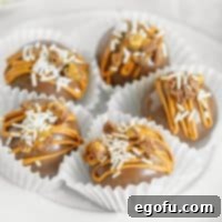 Square image of Chocolate Peanut Butter Hot Cocoa Bombs in paper liners on white plate.