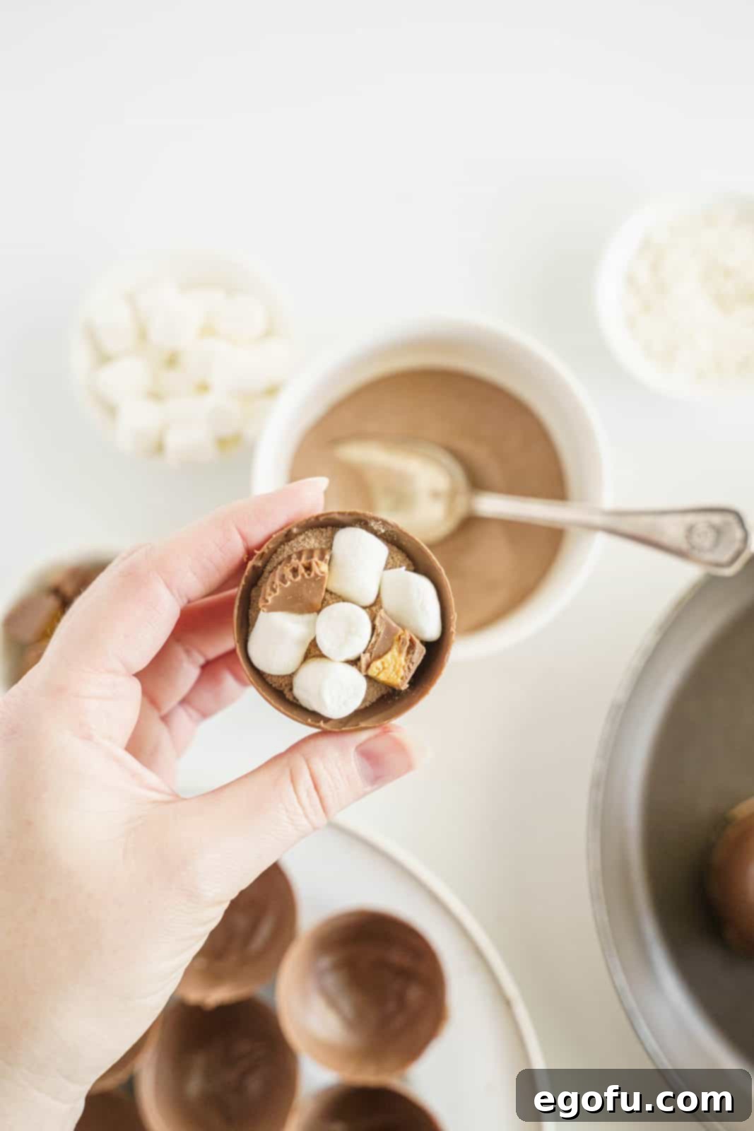 Hot cocoa, peanut butter cups and marshmallows added to inside one half of mold.