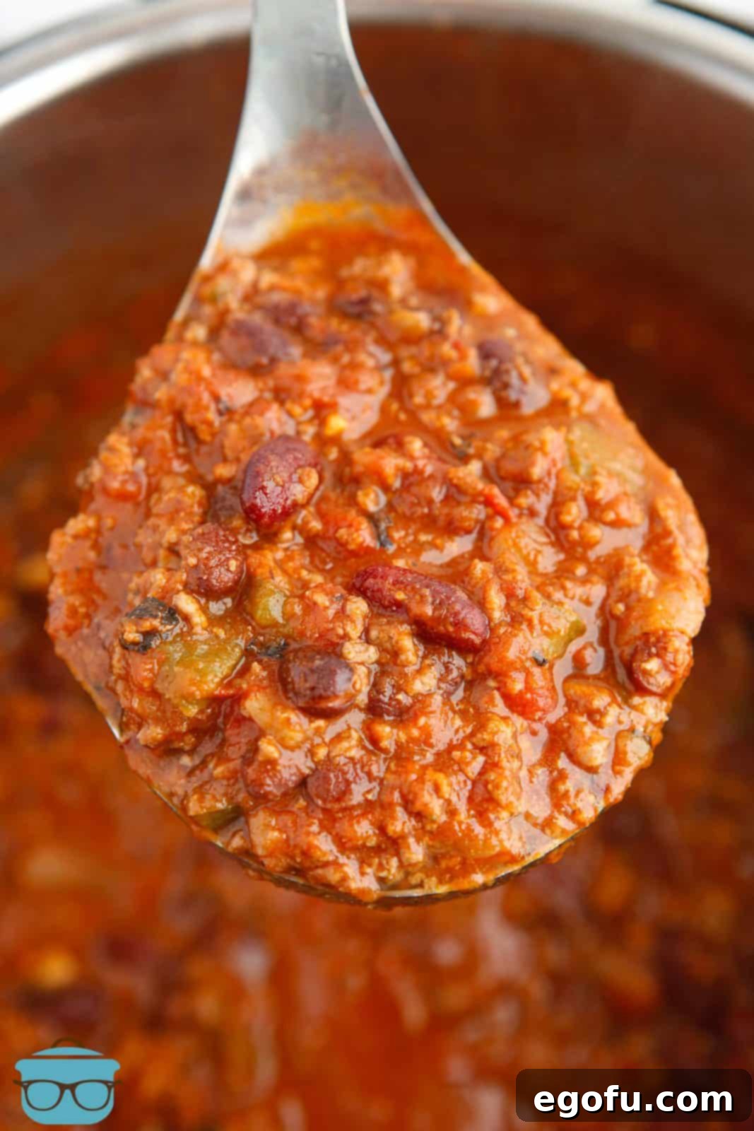 Spoon holding up finished Instant Pot Chili out of instant pot.