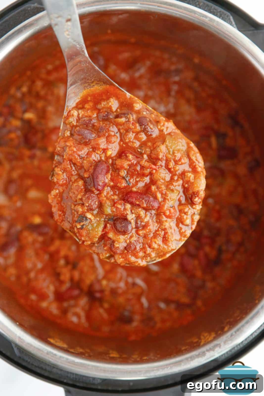 Spoon with Instant Pot Chili Recipe on it over instant pot.
