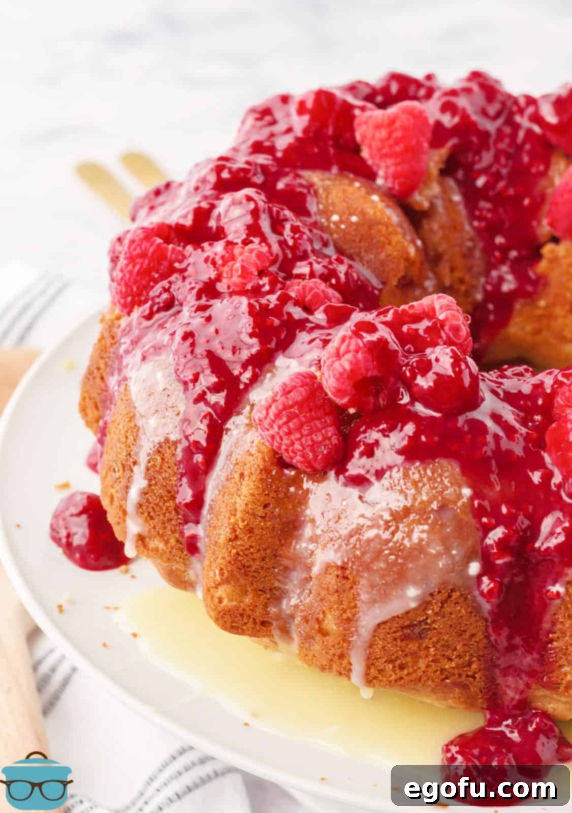 Overhead angle of White Chocolate Raspberry Cake with sauce poured over the top.
