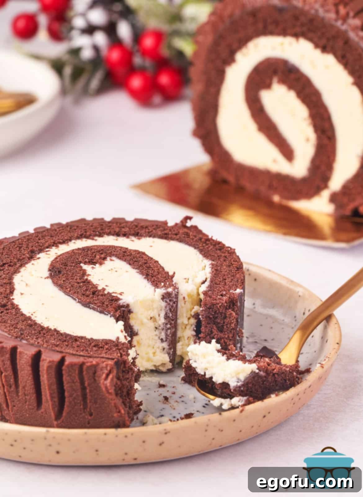 Slice of Christmas Yule Log Cake with bites taken out on plate.