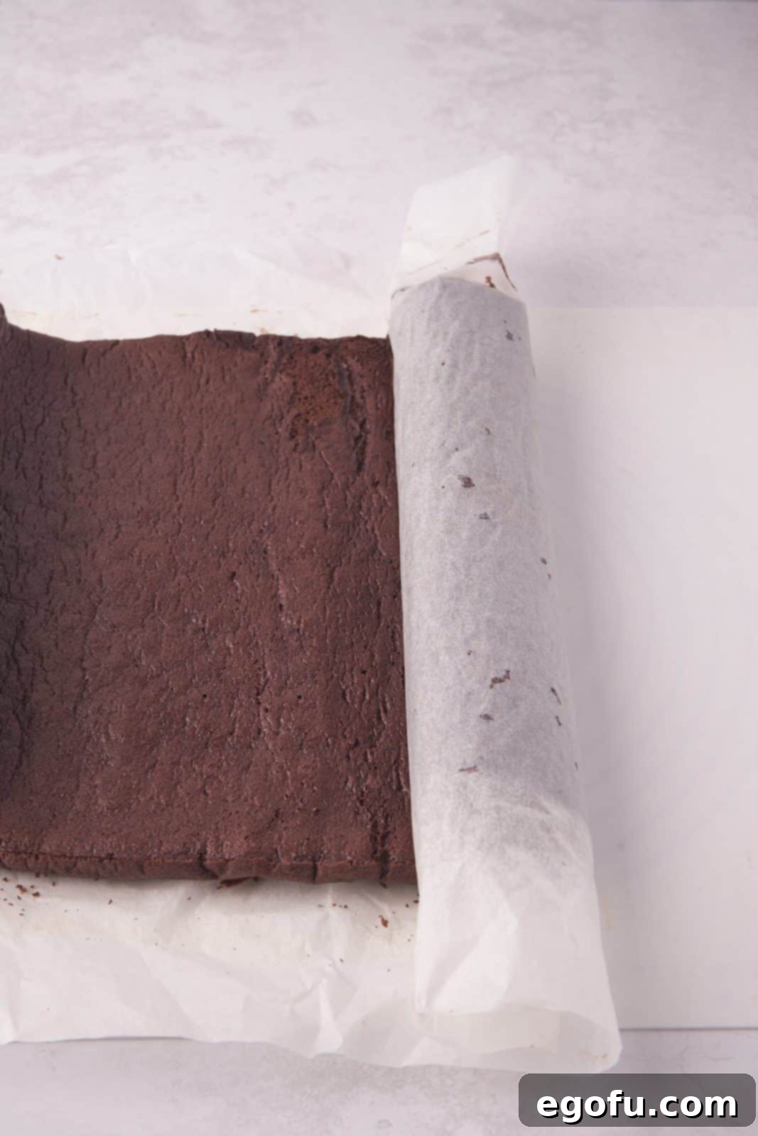 Cake being rolled up after baking.