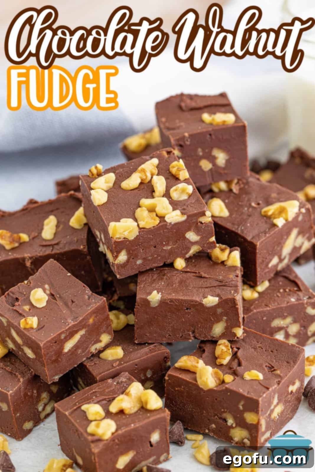 Pinterest image of Chocolate Walnut Fudge stacked, showcasing the visible walnuts embedded in the rich chocolate.